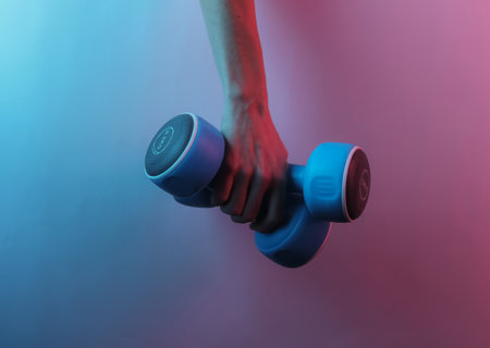 Female hand hold dumbbells. Creative pop art pink blue neon color. Trendy gradient illumination....