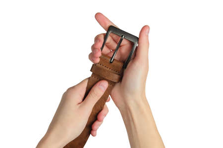 Female hand holds a leather brown belt isolated on white background