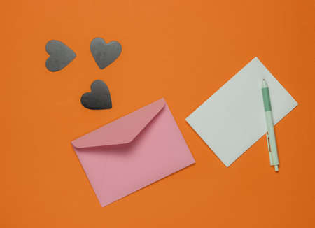 Envelope with a letter, pen, decorative hearts on yellow background. Flat lay mockup for Valentine's...