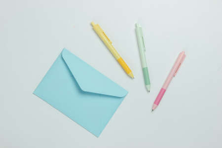 Envelope and colored pens on a white background. Top viewの写真素材