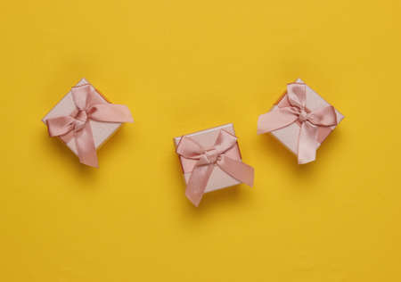 Gift boxes with bow on yellow background. Composition for christmas, birthday or wedding. Top viewの写真素材