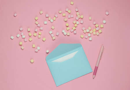 Blue Envelope with pen and marshmallows on pink background. Flat lay mockup for valentines day,...