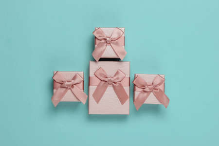 Gift boxes with bows on blue studio background. Composition for christmas, birthday or wedding. Top viewの写真素材