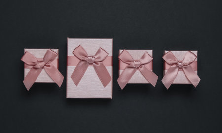 Gift boxes with bow on black background. Composition for Christmas, Black Friday, birthday or...