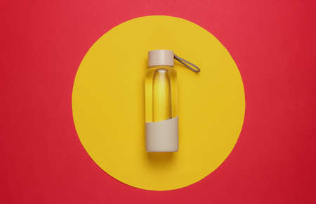 Bottle of water for sports and outdoor activities on red yellow circle background. Top viewの写真素材