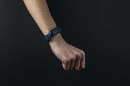Female hand with a smart bracelet on a black background. Modern gadgetsの写真素材