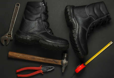 Flat lay composition with different industrial working tools and instruments, safety equipmen on black background. Top viewの写真素材