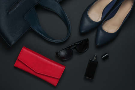 Women's accessories on a black background. High heel shoes, leather bag, purse, sunglasses, perfume...