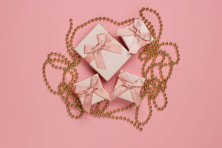 Gift boxes with bow, garlands on pink pastel background. Christmas concept. Top view