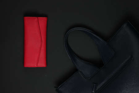 Women's accessories on a black background. Red purse, leather bag. Top viewの写真素材