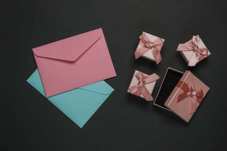 Envelope, boxes of gifts on black background. Christmas, Valentine's day, wedding or birthday. Top...