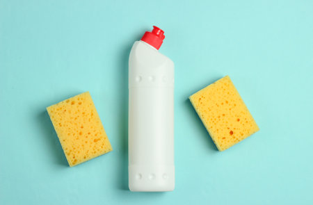 Cleaning concept. Detergent bottle, sponges on blue, pastel background. Top viewの写真素材