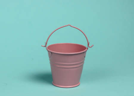 Pink empty mini bucket on blue pastel background. Minimalism. Trend color conceptの写真素材