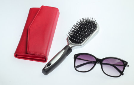 Leather purse, hair brush and sunglasses isolated on white background. Women's accessoriesの写真素材