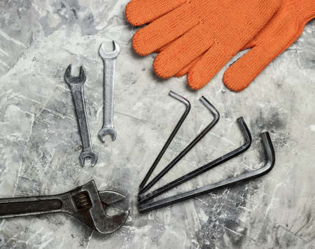 Set of wrench and gloves on gray concrete background. Work tool. Top view