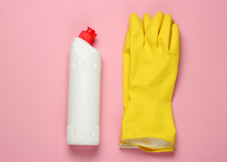 Ready for cleaning! Housework concept. Detergent bottle, gloves on pink pastel background. Top viewの写真素材