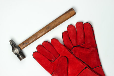 Red work gloves, hammer isolated on white background. Top viewの写真素材