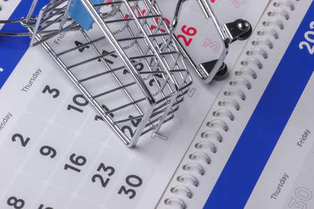 Seasonal discounts. Shopping trolley with calendar. Time to buy!の写真素材