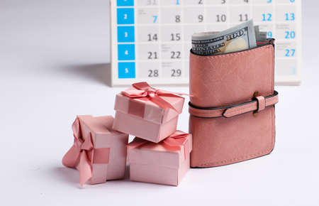Gift boxes with wallet, desktop calendar on white background. Holiday shopping, black friday, monthly special offer conceptの写真素材