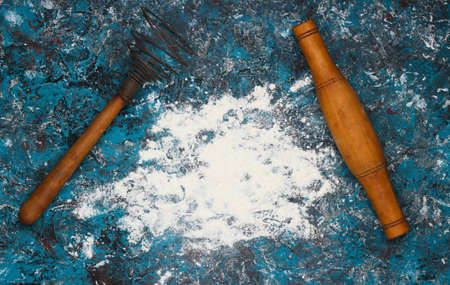 Flour and rolling pin on a blue concrete background. Top viewの写真素材