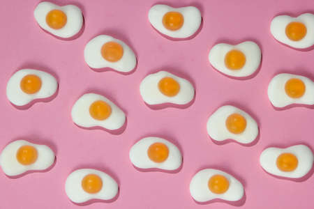 Pop art background. A lot of marmalade fried eggs on a pink pastel background. Minimalism food still lifeの写真素材