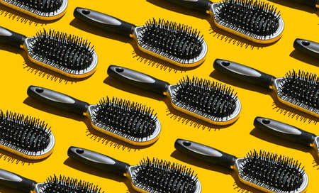 Hair Care Concept. Beauty pop art background. A lot of hairbrushes on yellow background.の写真素材