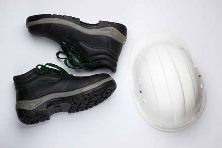 Safety equipment on a white background. Construction helmet, work leather shoes. Top viewの写真素材