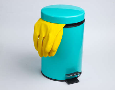 Yellow gloves in the bin on white background