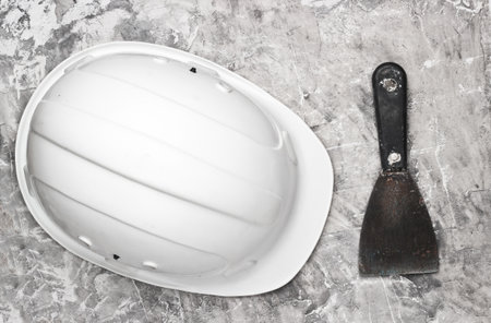 Trowel and construction helmet on gray concrete background. Builder equipment. Top viewの写真素材