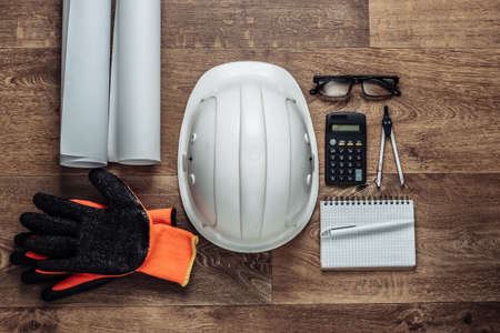 Creative layout of architects with roll drawings, engineering tools and stationery on floor,...