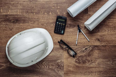 Creative layout of architects with roll drawings, engineering tools and stationery on floor,...