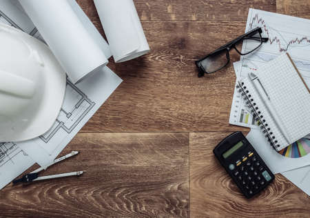 Architectural project plan, statistics and charts. Engineering tools and office supplies on floor,...