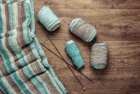 Home hobby. Skeins of woolen threads, yarn, knitted product on the floor. Top viewの写真素材