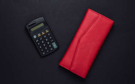Calculator with leather wallet on black background. Family bujet, economical calculation, additional accounts of expenses. Top viewの写真素材