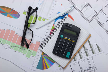 Classic eyeglasses, calculator, notebook with graphs and charts. Economic calculation, analytics,...