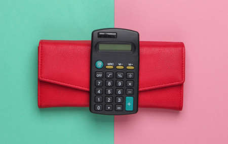 Calculator with a leather wallet on a blue-pink pastel background. Family bujet, economical calculation, additional accounts of expenses. Top viewの写真素材