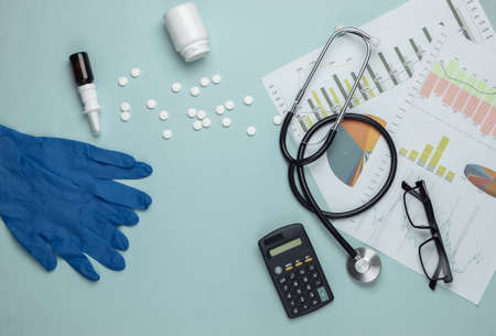 Economic analysis of medicine. Medical supplies and tools, graphs and charts on a blue background. Top viewの写真素材