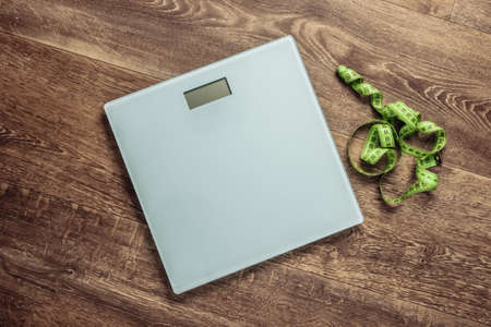 The concept of weight loss. Floor scales with dumbbells, measuring tape on the floor. Top viewの写真素材