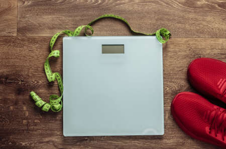 Fitness, slimming, diet concept. Floor weights, sneakers, measuring tape on the floor. Top viewの写真素材