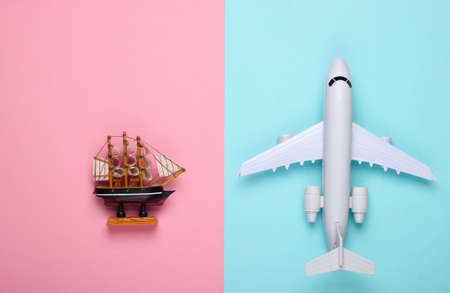 Flat lay travel design. Figurine of a ship, airplane on a blue-pink pastel background. Top view