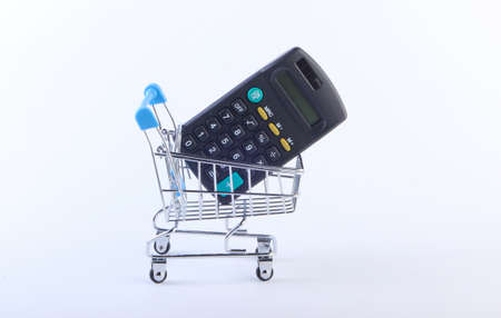 Mini Shopping basket with calculator on white background. Calculation of the cost of purchases in supermarket, economy.の写真素材