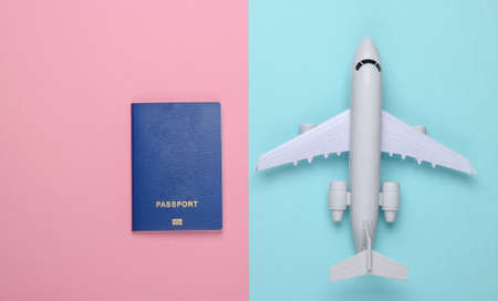Flat lay travel composition on a blue-pink background. Plane figurine, passport. Rest, vacation and tourism or emigration. Top view.  Minimalismの写真素材