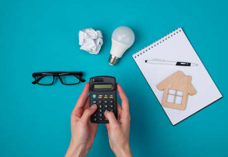 Female hands count calculator. Economic calculation of the cost of housing. Top viewの写真素材
