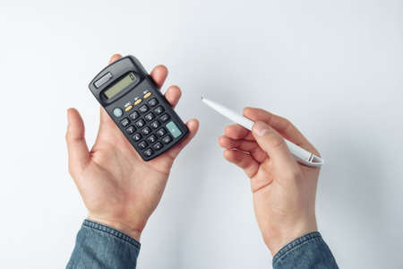 Male hands count on a calculator on white background