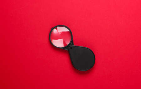 Pocket magnifier on red background. Top viewの写真素材