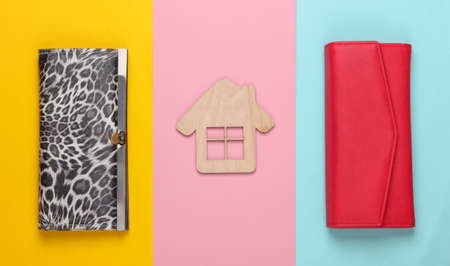 Figurine of a house with wallets on colored backgrounds. Family budget. Payment of rent for housing. Top viewの写真素材