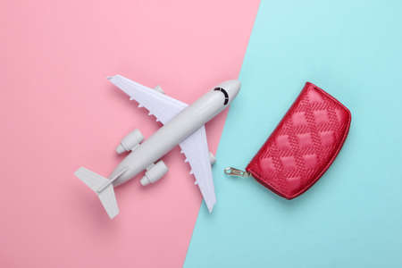 Flat lay design of travel concept with plane and wallet. Pink blue pastel background. Minimalism. Top viewの写真素材