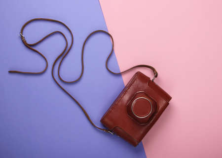 Retro camera in a leather case on a pink-purple pastel background. Top viewの写真素材
