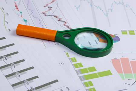 Magnifier closeup with graph and charts. Economic analysis, calculation, statistics