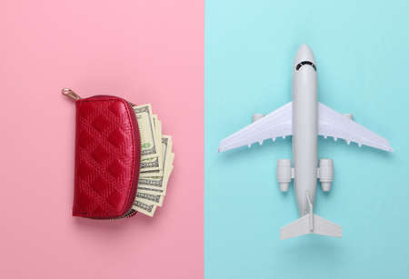Flat lay design of travel concept with plane and wallet. Pink blue pastel background. Minimalism....